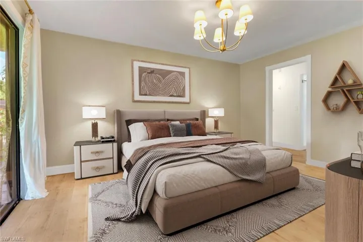 Bedroom featuring light wood finished floors and a chandelier