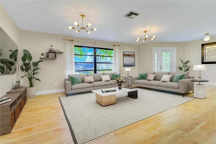 Living area with a chandelier and light wood-style floors