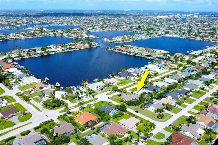 Aerial view of property and surrounding area featuring nearby suburban area and a nearby body of water