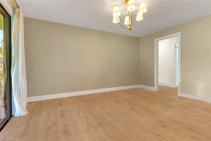 Unfurnished dining area with a chandelier and light wood-style flooring
