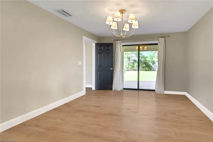 Spare room with a chandelier and light wood-style floors