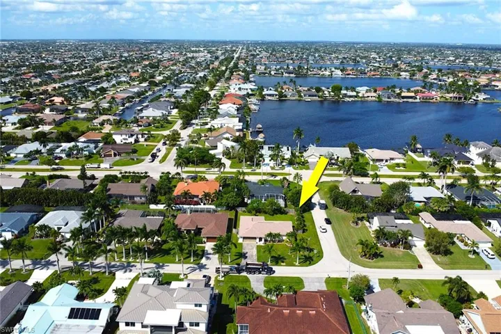 Aerial view of property and surrounding area with a nearby body of water and nearby suburban area