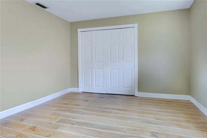 Unfurnished bedroom with wood finish floors and a closet
