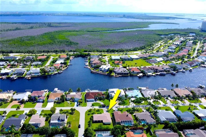 Aerial view of property's location with a large body of water and nearby suburban area