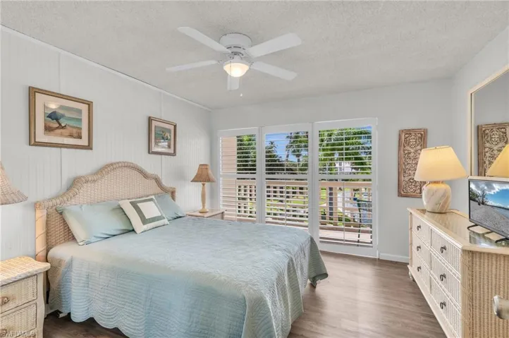 Bedroom featuring wood finished floors, a textured ceiling, and a ceiling fan