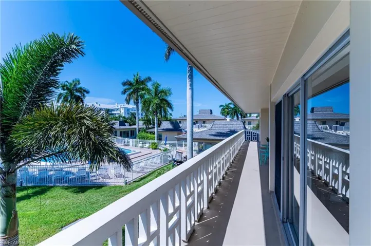 Balcony featuring view of pool area
