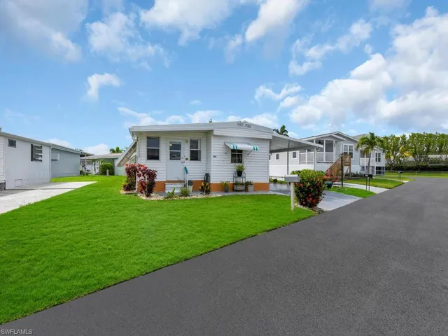 Manufactured / mobile home featuring a carport and a front yard