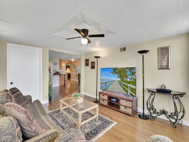 Living room featuring wood-type flooring and ceiling fan