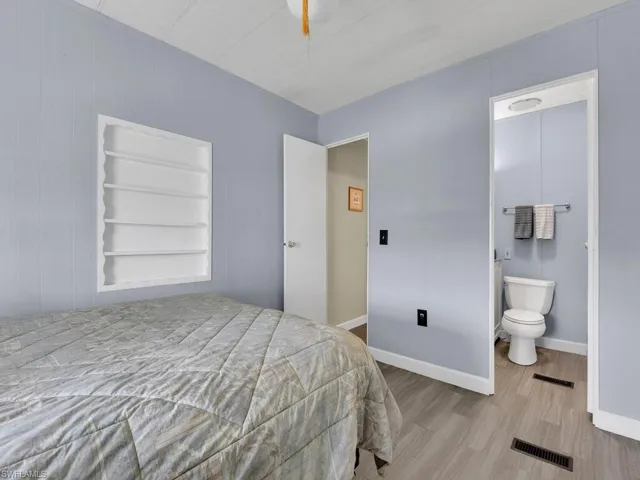 Bedroom with ensuite bathroom and light wood-type flooring