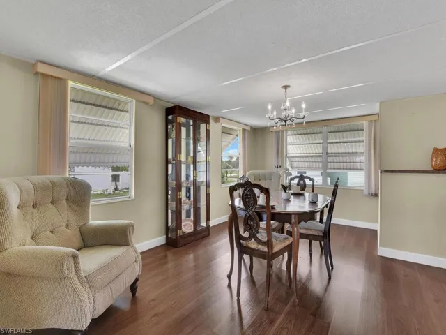 Dining room with a chandelier, a textured ceiling, and dark wood-type flooring