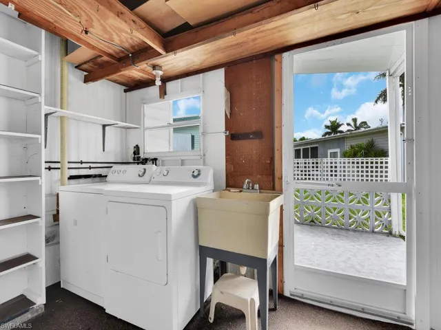 Clothes washing area with washer and clothes dryer, sink, and plenty of natural light