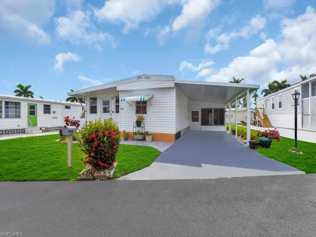 Manufactured / mobile home with a carport and a front lawn