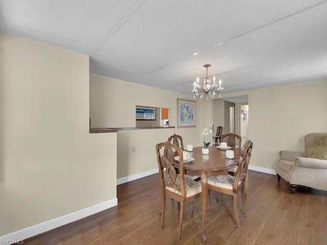 Dining area featuring a chandelier, a textured ceiling, and dark hardwood / wood-style floors