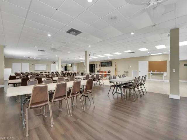 Dining space with wood-type flooring, ceiling fan, and a drop ceiling