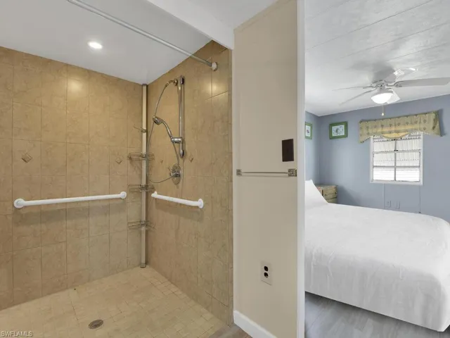 Bathroom with a tile shower and ceiling fan