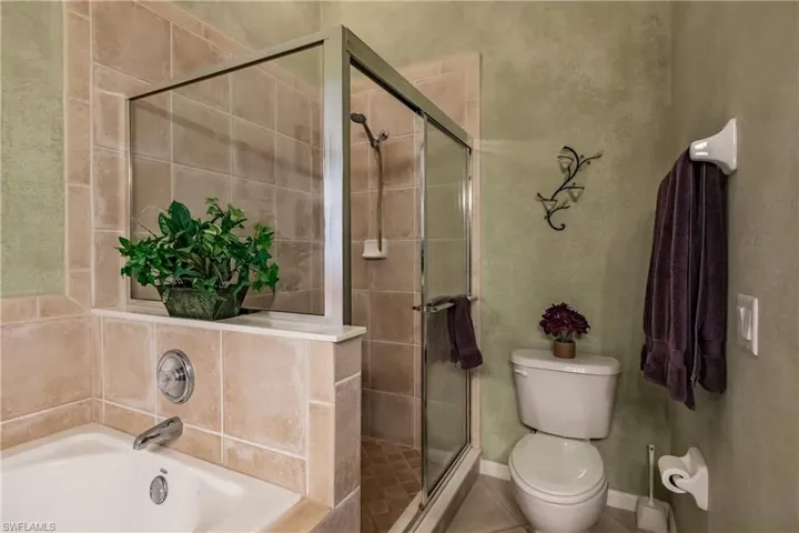 Bathroom with a garden tub, a shower stall, and tile patterned flooring
