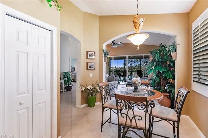 Tiled dining room featuring arched walkways and a ceiling fan