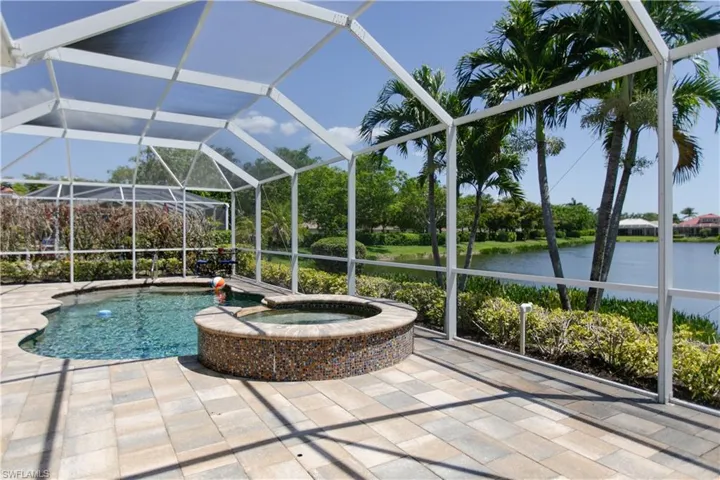 View of pool with a water view, a patio area, a pool with connected hot tub.