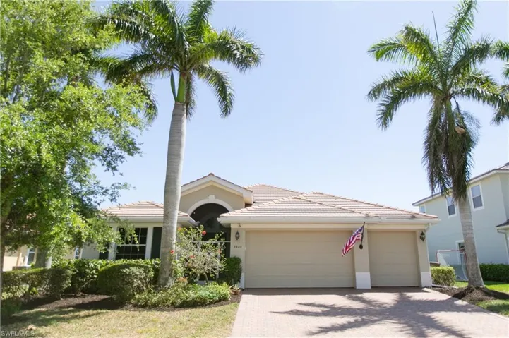 Single story home with a tiled roof, a garage, decorative driveway, and stucco siding