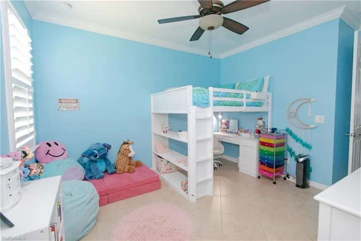 Bedroom featuring baseboards, tile floors, and crown molding