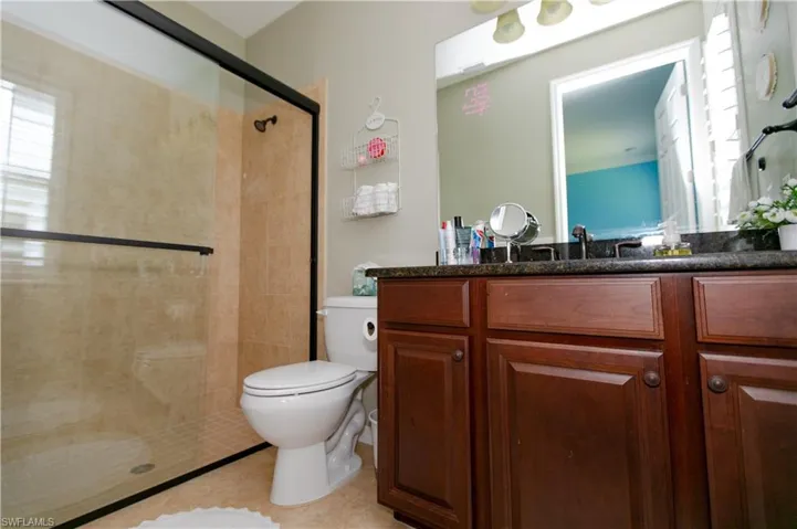 Full bathroom featuring a shower stall, vanity, and toilet