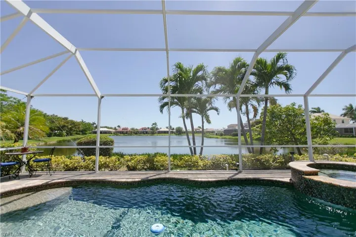 View of swimming pool featuring a water view, a patio, a pool with connected hot tub, and a lanai