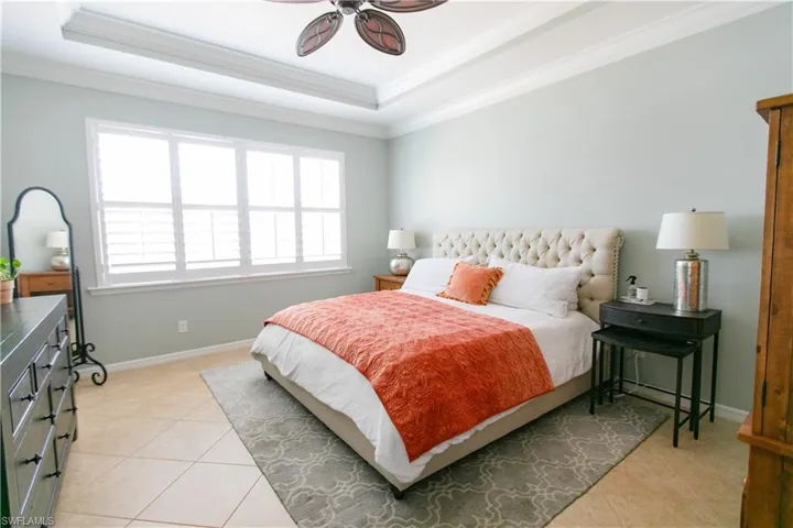 Bedroom featuring ceiling fan, crown molding, and light tile patterned floors