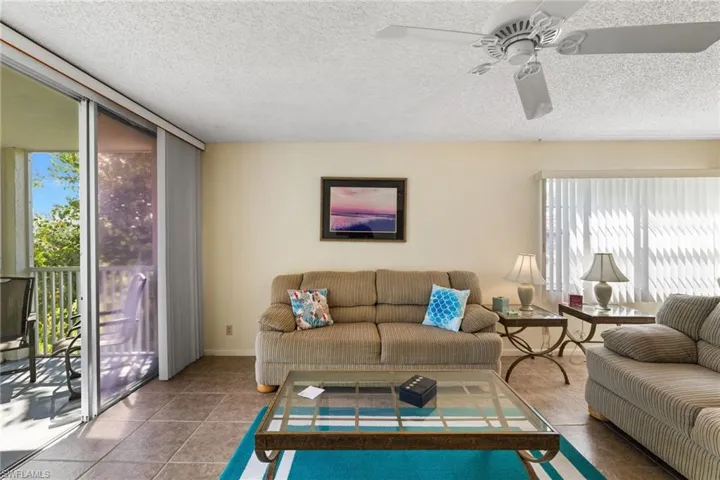 Living room with a textured ceiling and tile patterned flooring