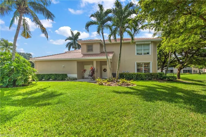 View of side of house featuring side yard, stucco siding, and a tile roof