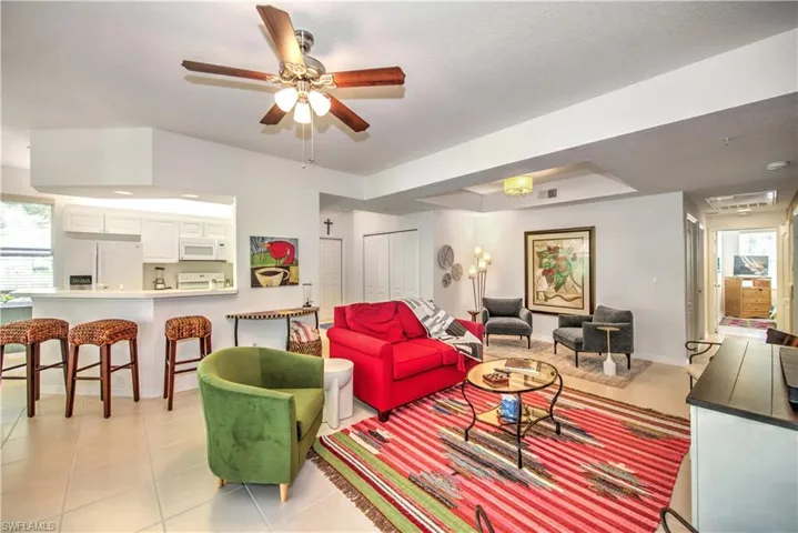 Living area with plenty of natural light, light tile patterned floors, and ceiling fan