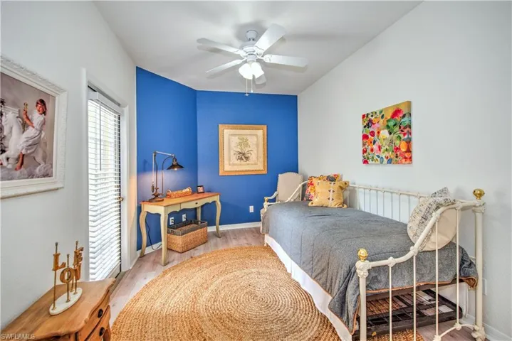 Bedroom featuring wood finished floors, a ceiling fan, and radiator