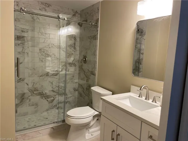 Bathroom with a shower stall, vanity, and light tile patterned floors