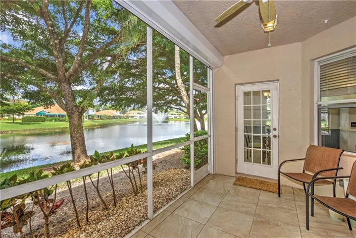 Sunroom with a water view, a textured ceiling, and tile patterned flooring