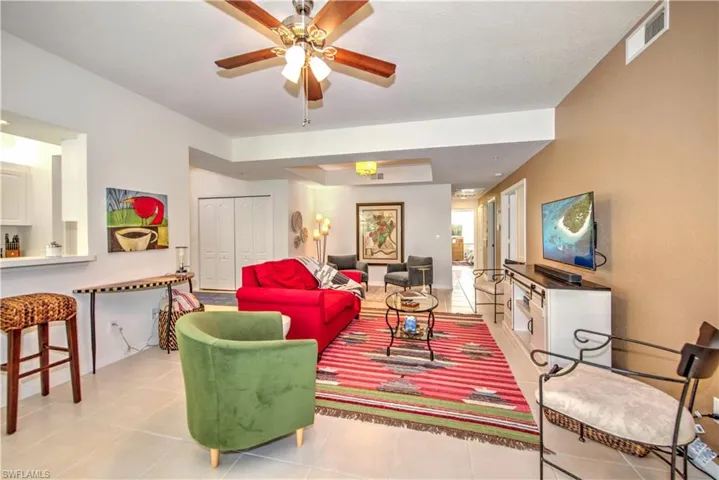 Living area featuring light tile patterned floors and a ceiling fan