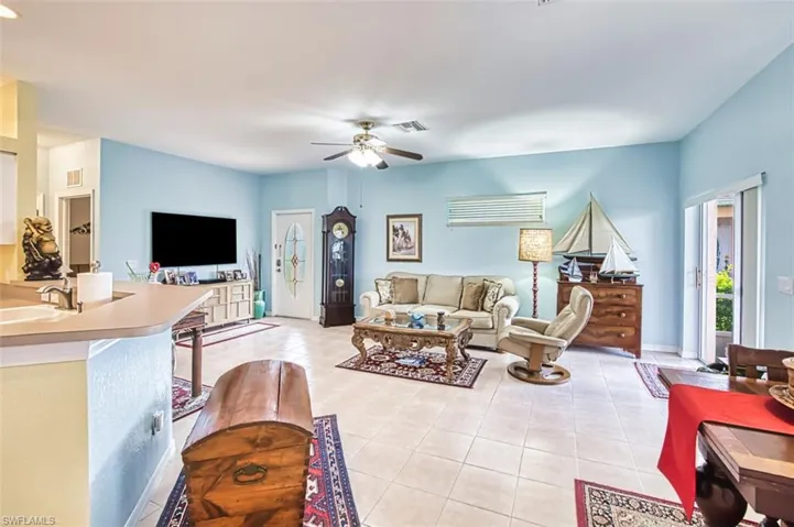 Living area featuring light tile patterned floors and a ceiling fan