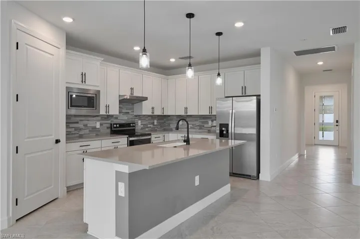 Kitchen with island featuring views to foyer and front door