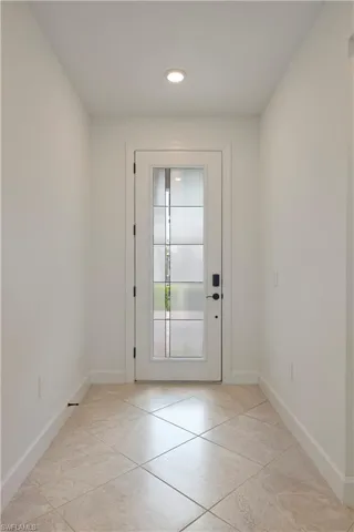 Doorway featuring light tile patterned floors