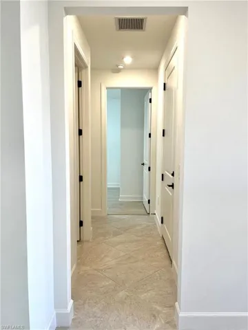 Hallway featuring light tile patterned floors