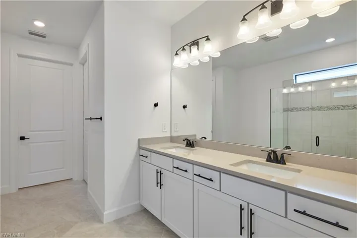 Primary bathroom with frameless shower, and double sink vanity