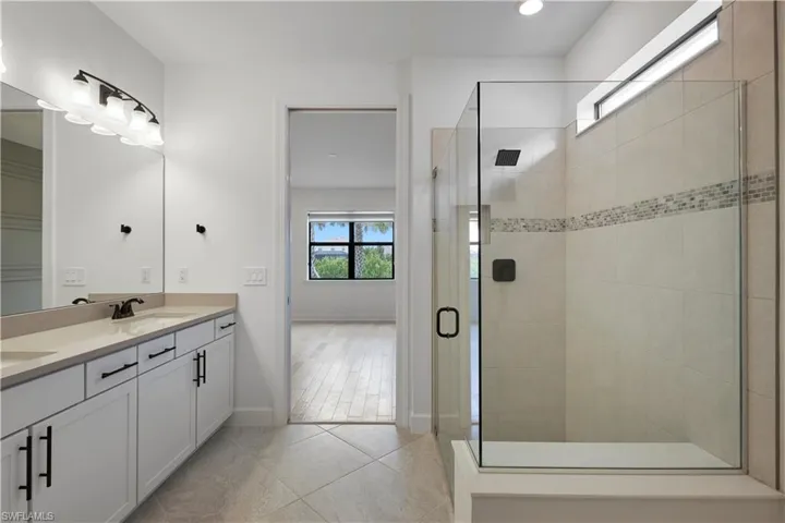 Primary bathroom with frameless shower, and double sink vanity