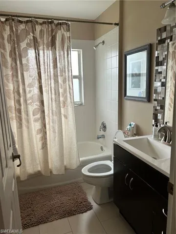 Bathroom with vanity and shower / tub combo with curtain