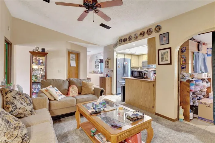 Carpeted living room featuring a textured ceiling and ceiling fan