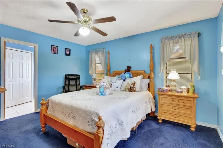 Bedroom with carpet, ceiling fan, a closet, and a textured ceiling