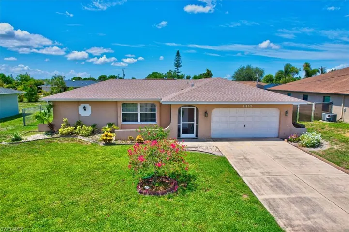 Single story home with a front yard and a garage