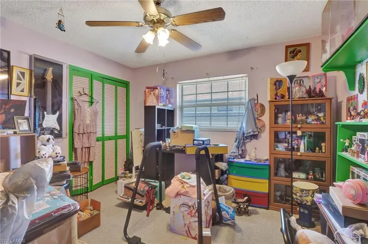 Office space with carpet flooring, ceiling fan, and a textured ceiling