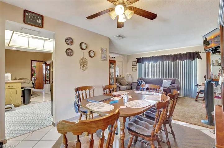 Tiled dining area with ceiling fan and a textured ceiling