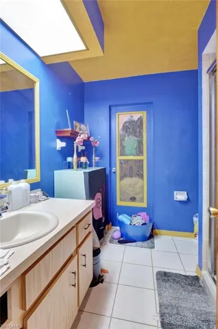 Bathroom with vanity, tile floors, and a shower with door