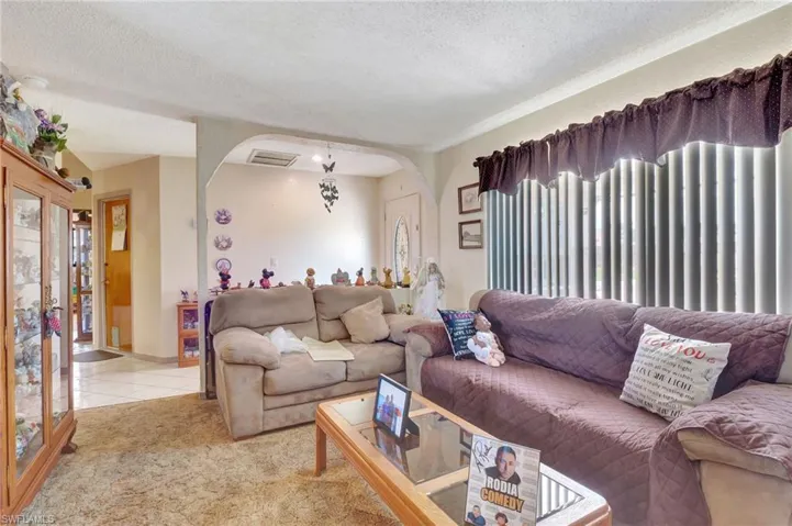 Carpeted living room featuring plenty of natural light and a textured ceiling