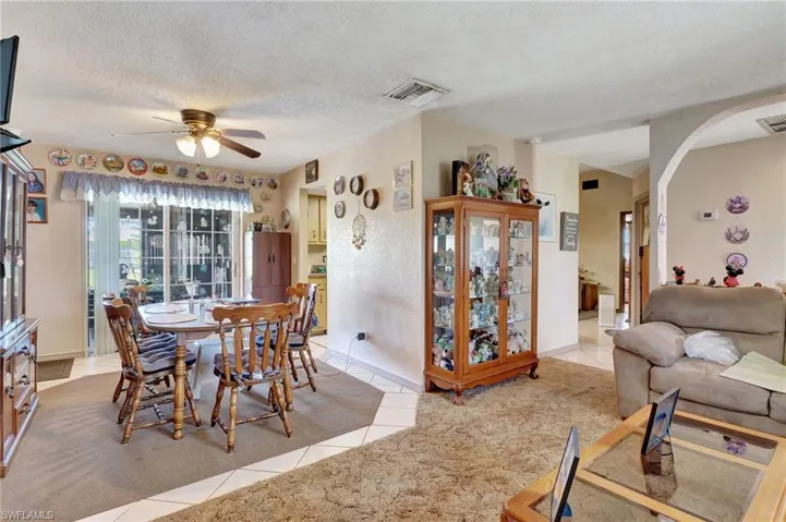 Dining room with a textured ceiling, carpet flooring, and ceiling fan