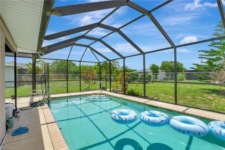 View of swimming pool with glass enclosure and a lawn